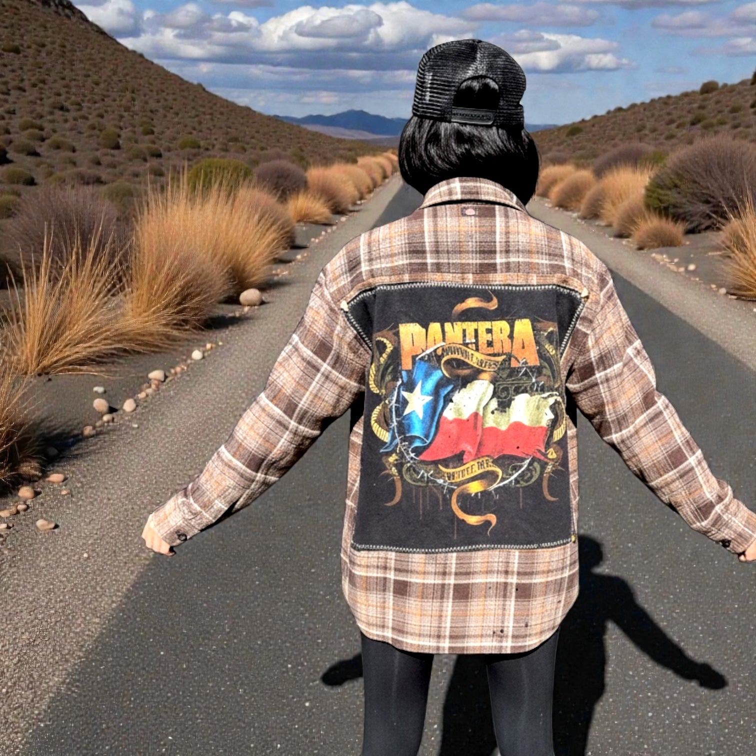 Model wearing a flannel shirt featuring Pantera graphics in the Backstage Bruisers collection on a desert road.